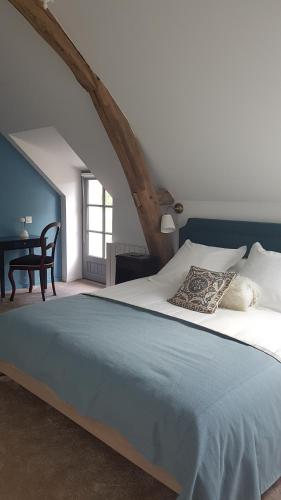 a bedroom with a large bed and a table at Les 7 Tilleuls - Chambres d'hôtes in Mesland