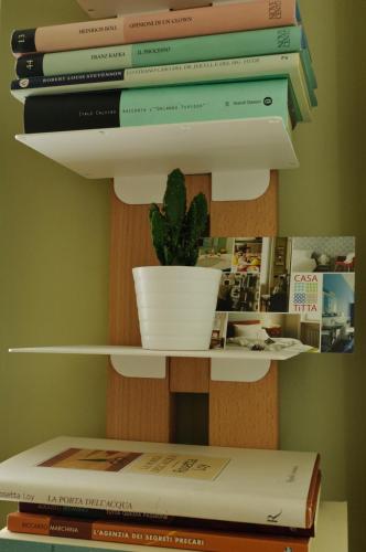 a stack of books on a shelf with a plant at Casatitta Bed & Breakfast in Milan
