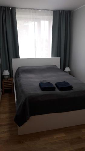 a bedroom with a bed with two blue towels on it at Kurzemītes apartamenti in Kuldīga