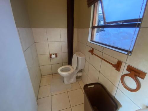 a small bathroom with a toilet and a window at Outspan Safaris in Komga