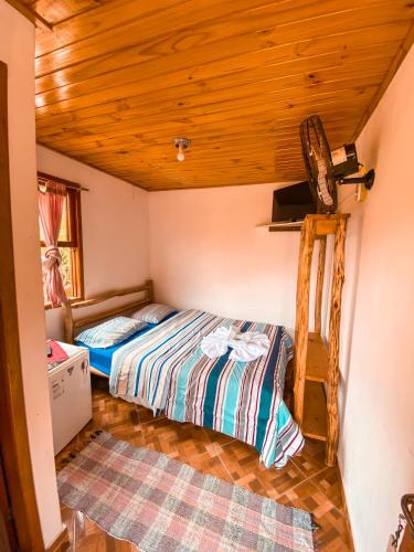a bedroom with two beds and a wooden ceiling at Pousada Cantinho da Montanha 2 in Visconde De Maua