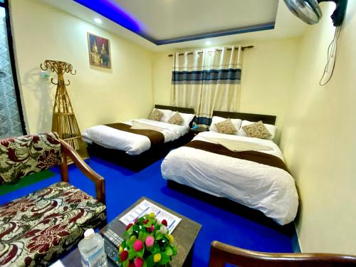 a room with two beds and a table with a camera at Hotel Yog Darshan in Kathmandu