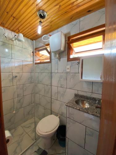 a small bathroom with a toilet and a sink at Pousada Cantinho da Montanha 2 in Visconde De Maua