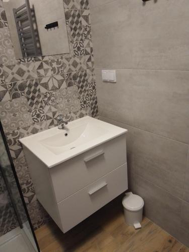 a bathroom with a white sink and a toilet at Orange Apartament in Wadowice