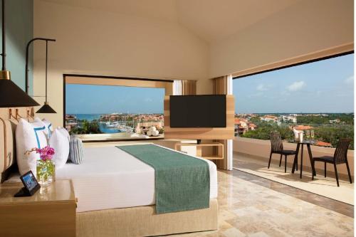 a bedroom with a large bed with a large window at Dreams Aventuras Riviera Maya - All Inclusive in Puerto Aventuras