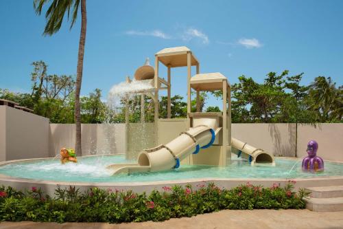 een waterglijbaan in een zwembad bij een waterpark bij Dreams Aventuras Riviera Maya - All Inclusive in Puerto Aventuras