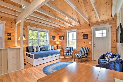 een woonkamer met een blauwe bank en een tafel bij Cozy Cedarville Cottage - Walk to Lake Huron! in Cedarville