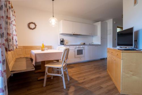 een keuken en eetkamer met een tafel en stoelen bij Unterbrunnerhof in Lana