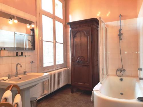 une salle de bain avec une baignoire et un lavabo et une baignoire dans l'établissement Manoir des Tuileries du Buisson, à Verneuil-sur-Avre