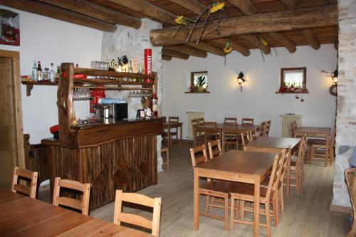 a restaurant with wooden tables and chairs and a bar at Agriturismo AGRIMON in Sabbio Chiese