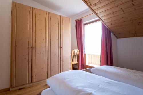 1 dormitorio con 2 camas y ventana en Unterbrunnerhof, en Lana