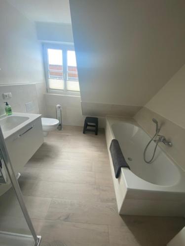 a bathroom with a tub and a sink and a toilet at Inselperle - Kämmererhof in Fehmarn