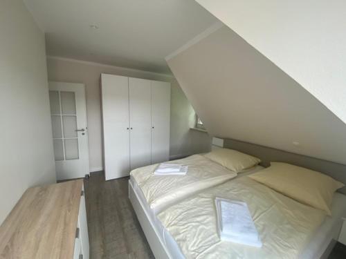 a bedroom with a white bed in a attic at Kämmererhof - Inselperle in Fehmarn