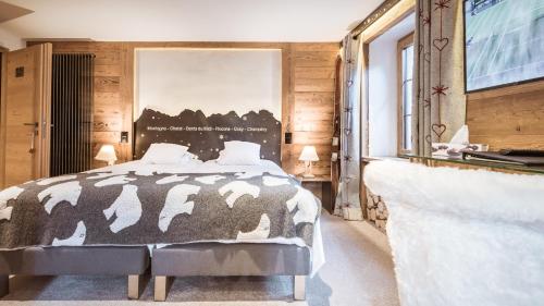 1 dormitorio con 1 cama con manta blanca y negra en Le Chalet de l'Atelier - Le Nord, en Champéry