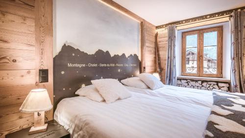 ein Schlafzimmer mit einem großen Bett mit weißen Kissen in der Unterkunft Le Chalet de l'Atelier - Le Nord in Champéry