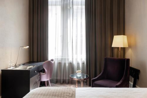 a hotel room with a bed and a desk and a chair at Elite Plaza Hotel in Gothenburg