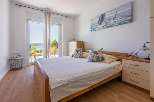 a bedroom with a bed and a large window at Apartments Milica in Crikvenica