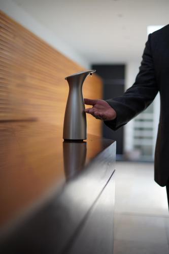 a man in a suit standing next to a coffee machine at Hotel Los Juaninos in Morelia