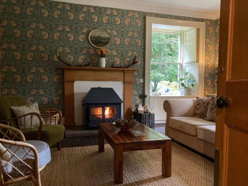 a living room with a couch and a fireplace at Heathpark House in Blairgowrie