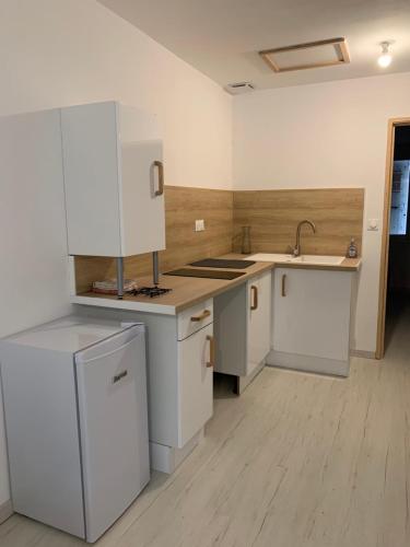 une cuisine vide avec des placards blancs et un évier dans l'établissement la pinède, à Mornas