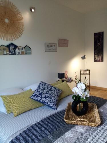 - une chambre avec un lit orné d'un vase de fleurs dans l'établissement Sucrée et Douceur, à Cabourg