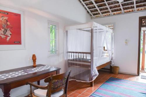 a room with a crib and a table and a desk at Villa Templeberg in Galle