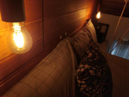 a couch in a room with a light and a lamp at Loft encantador D - 8 km de Floripa in São José
