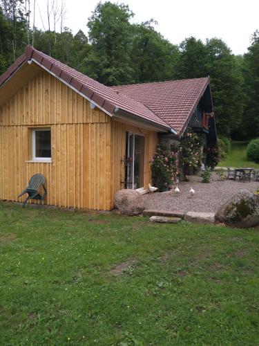 a house with a yard with chickens in front of it at Gite Spa Détente Nature L'Estompe in Fresse