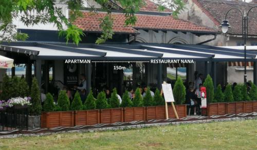 a restaurant with people sitting outside of it at Apartments NANA in Golubac
