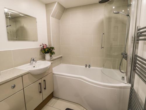 a bathroom with a tub and a sink and a shower at 18 High Street in Northallerton