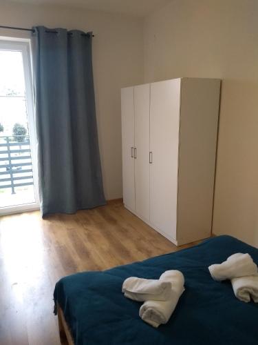 a bedroom with a bed and a large window at Orange Apartament in Wadowice
