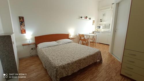 Fontanarossa Airport Apartment في كاتانيا: غرفة نوم بسرير وطاولة مع كراسي