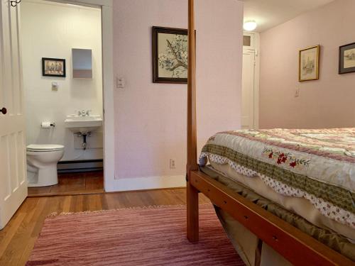 a bedroom with a bed and a bathroom with a sink at Franklyn Farm Inn in Chester