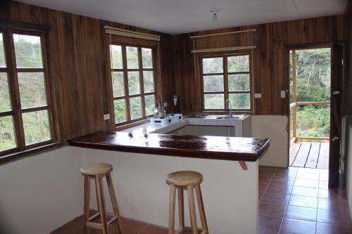 eine Küche mit einer Theke und 2 Barhockern in der Unterkunft Casa Colibrí in La Suiza