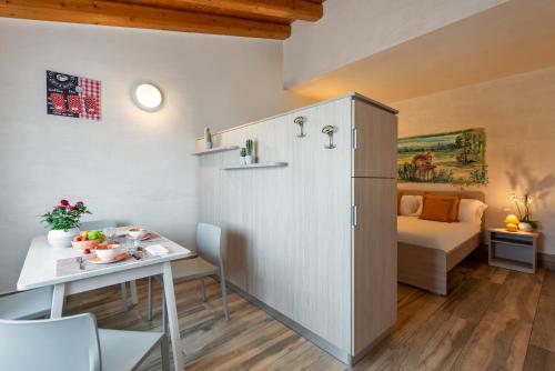 a small apartment with a table and a bed at Sporting Hotel San Felice in Illasi