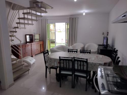 ein Wohnzimmer mit einem Esstisch und Stühlen in der Unterkunft Vila da Praia in Florianópolis