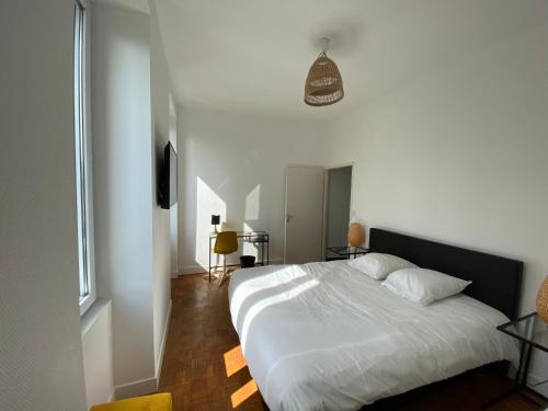 a bedroom with a white bed and a window at Maison By Logis - Appartement T4 - La Maison d'Hestia in Vierzon
