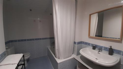 a bathroom with a sink and a toilet and a mirror at Piso Casa Reina Un lugar cerca del mar y el puerto in Gandía