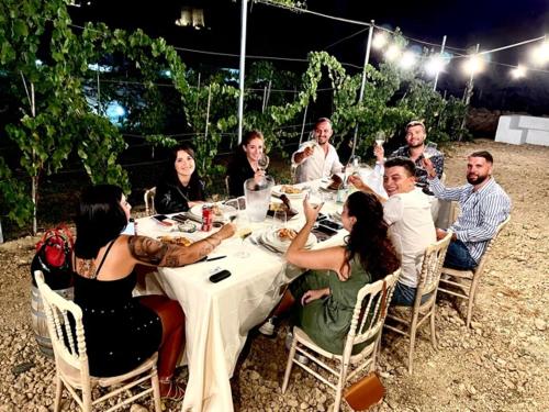 a group of people sitting around a table eating at Cantine De Mare - Wine and Resort in Cirò Marina