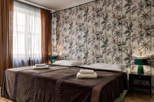 - une chambre avec un grand lit et du papier peint floral dans l'établissement Louren - The Bridge Inn, à Prague