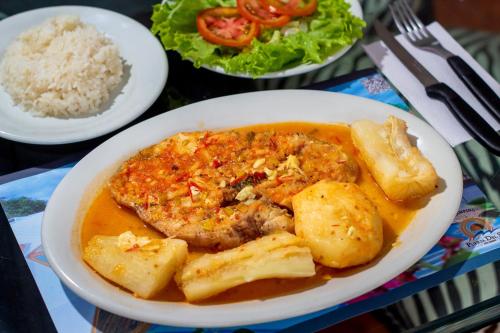 a plate of food with meat and potatoes and rice at Glamping Girardot & Hotel Puerta Del Sol Girardot in La Virginia