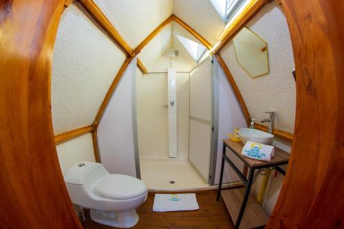 a bathroom with a toilet and a shower and a sink at Glamping Girardot & Hotel Puerta Del Sol Girardot in La Virginia
