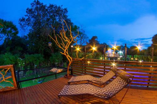 a hammock sitting on a deck at night at Glamping Girardot & Hotel Puerta Del Sol Girardot in La Virginia