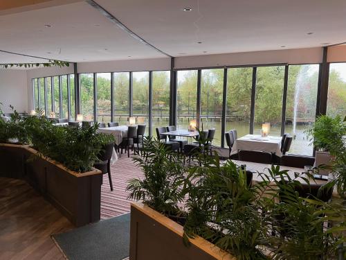 a restaurant with tables and chairs and large windows at TheWaterfrontLodges in Coventry