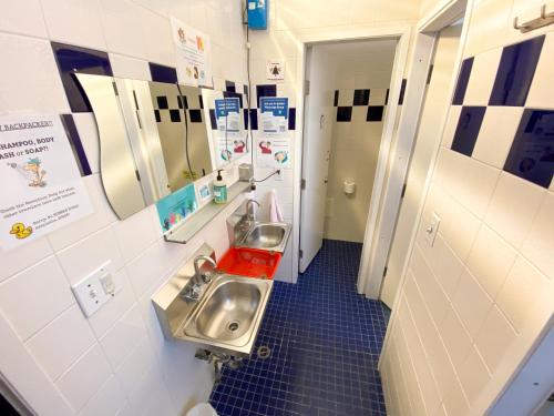a bathroom with two sinks and two mirrors at ITH San Francisco Pacific Tradewinds Backpacker Hostel in San Francisco