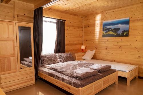 ein Schlafzimmer mit einem Bett in einer Holzhütte in der Unterkunft Почивна станция Сомат in Dospat