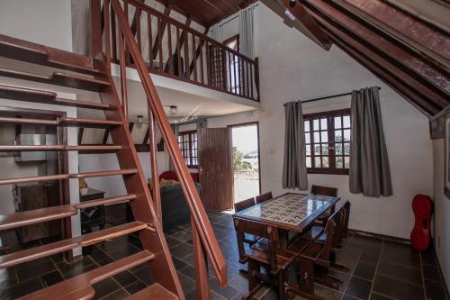 a room with a wooden spiral staircase and a table at Chalés da Cuesta in Pardinho