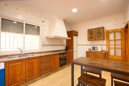 a kitchen with wooden cabinets and a wooden table at Cuencaloft Villa del Tío Tomarro in Villalba de la Sierra
