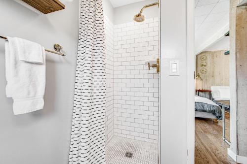 La salle de bains blanche est pourvue d'une douche avec une porte en verre. dans l'établissement Melody Vineyard Cottage, à Guerneville