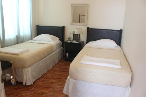 a room with two beds and a table with a mirror at Hotel Cruz Grande-Brava in Vila Nova Sintra